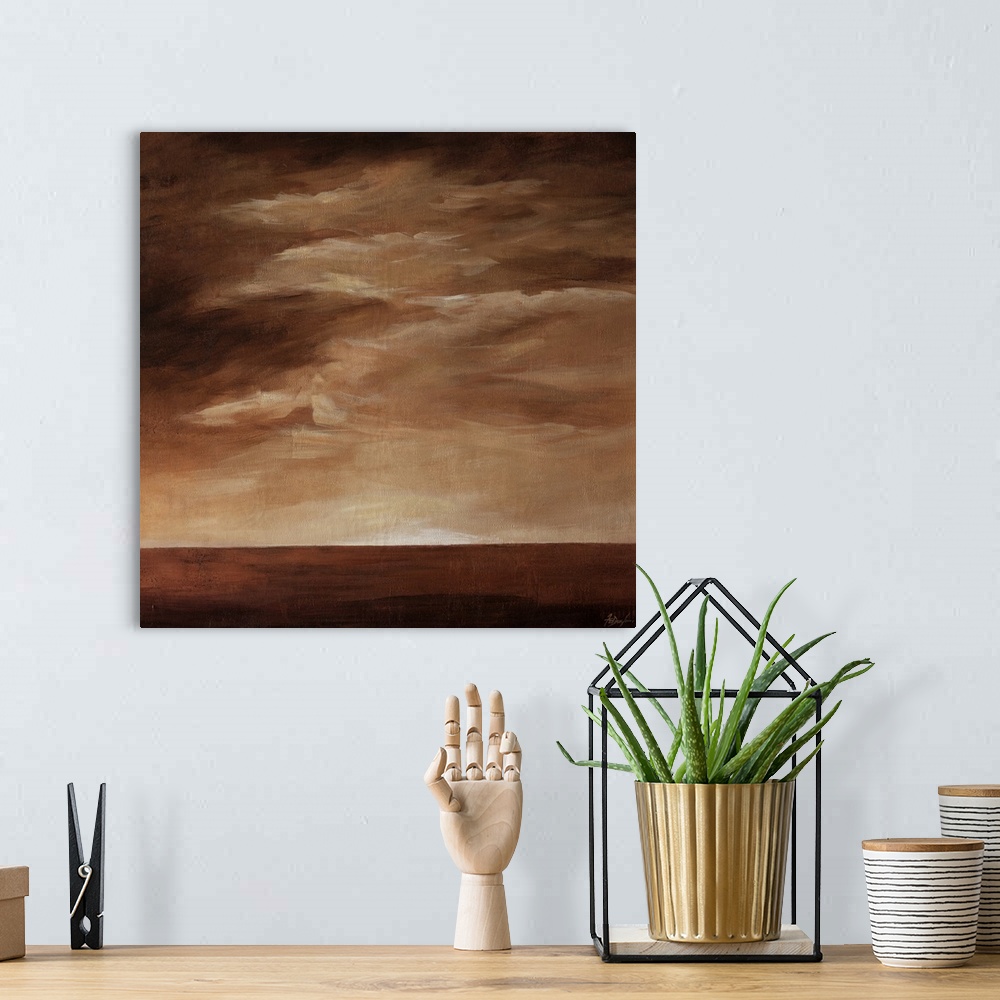 A bohemian room featuring Contemporary landscape painting in brown tones with a cloudy sky.