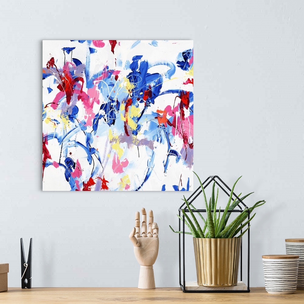 A bohemian room featuring A contemporary abstract painting of various vibrant colors dancing around a white space.