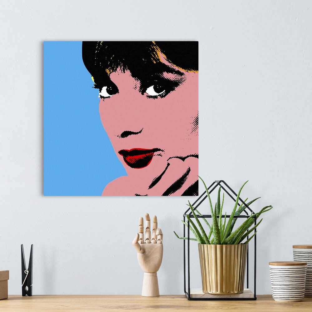 A bohemian room featuring Retro artwork of Audrey Hepburn where only her face and hand holding it up are shown.