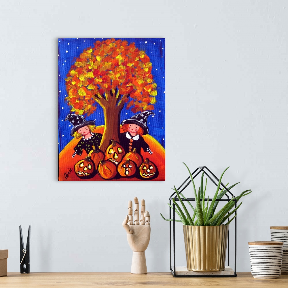A bohemian room featuring Two little witches are peeking out from behind a colorful fall tree. A grouping of Jack-O-Lantern...