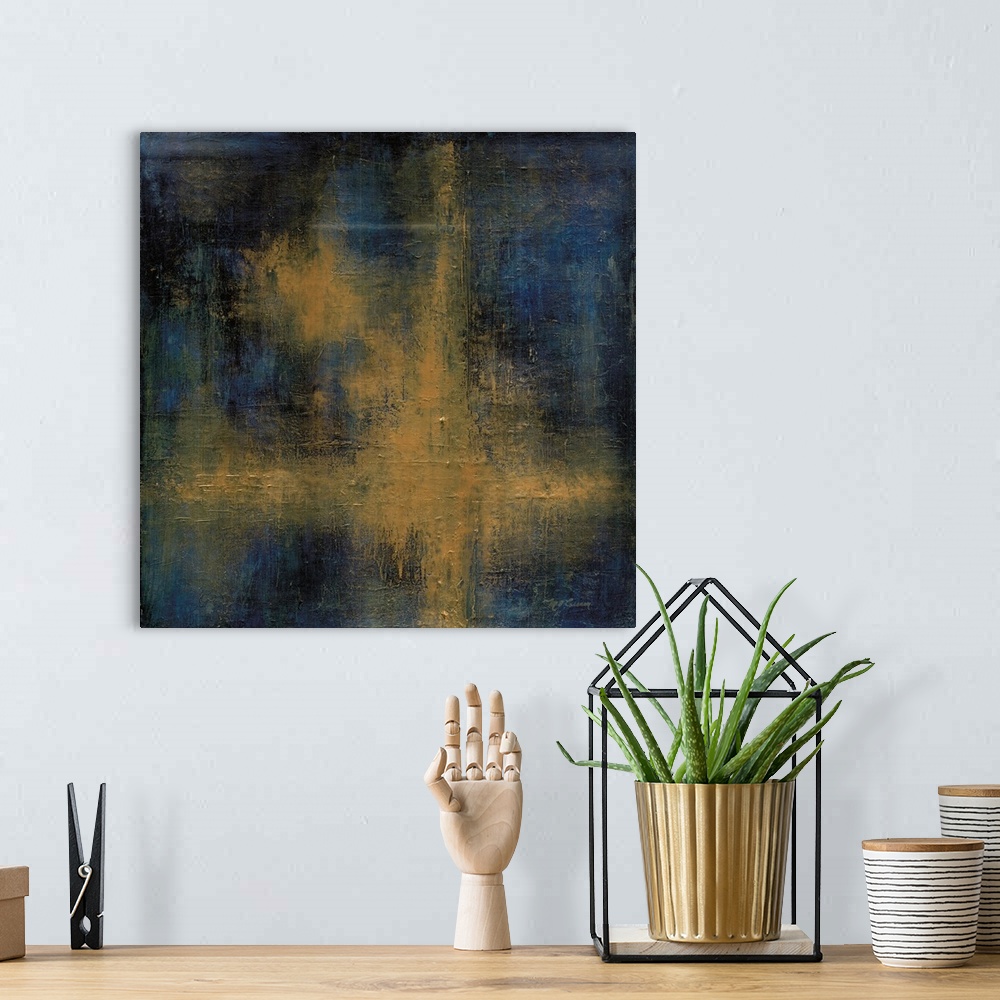 A bohemian room featuring A square abstract painting of yellow, black and blue in a cross shape.