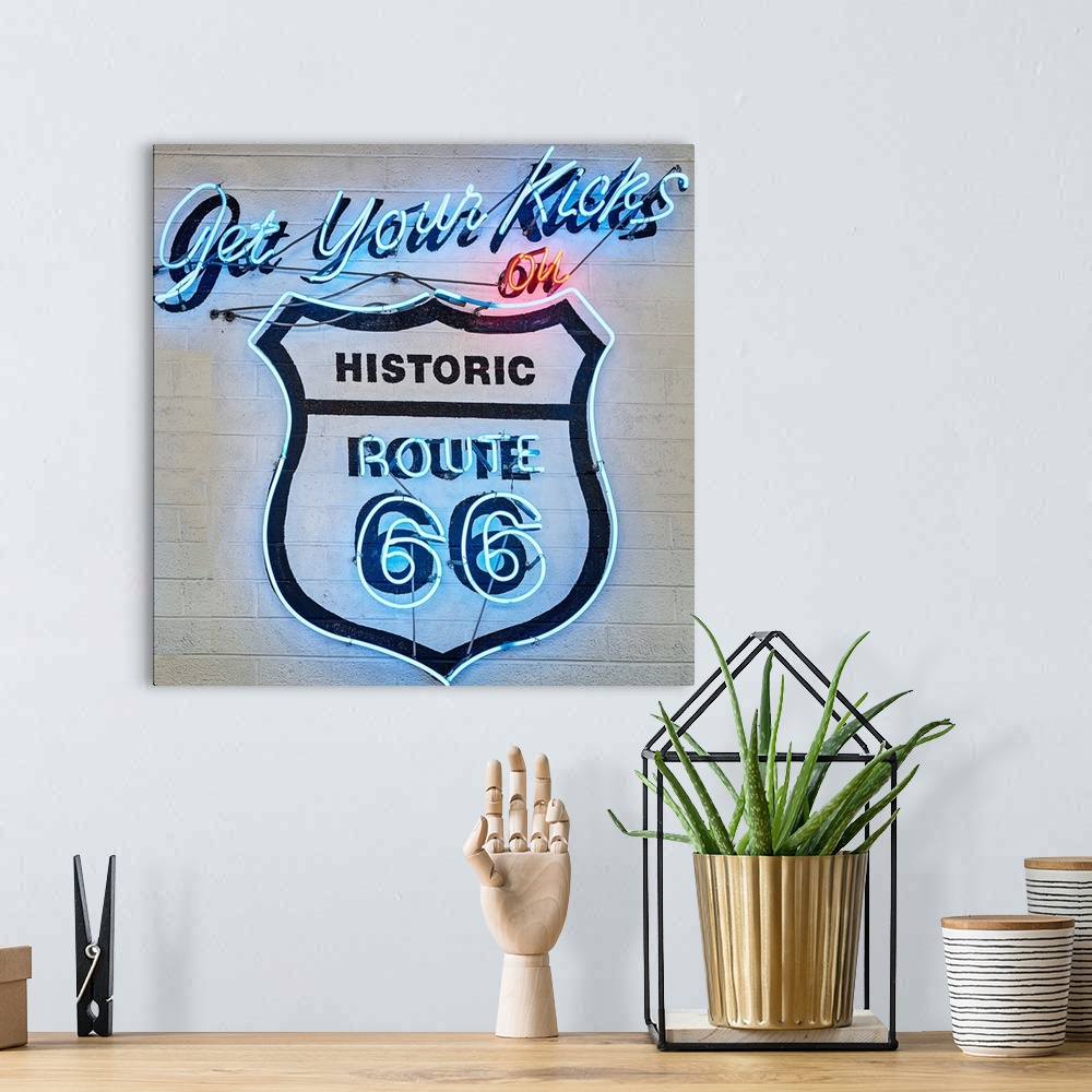 A bohemian room featuring Square photograph of a neon Route 66 sign on a wall.
