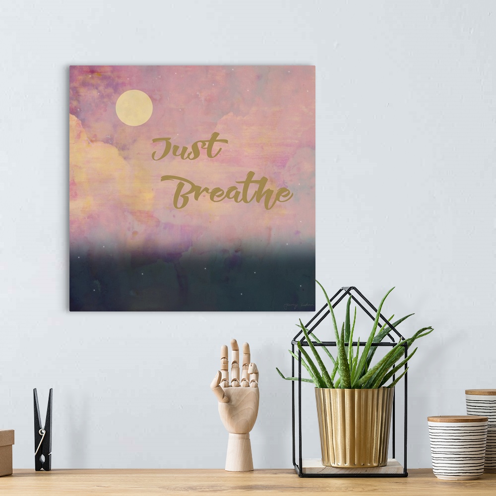 A bohemian room featuring "Just Breathe" in gold with a pink cloud design in the background.