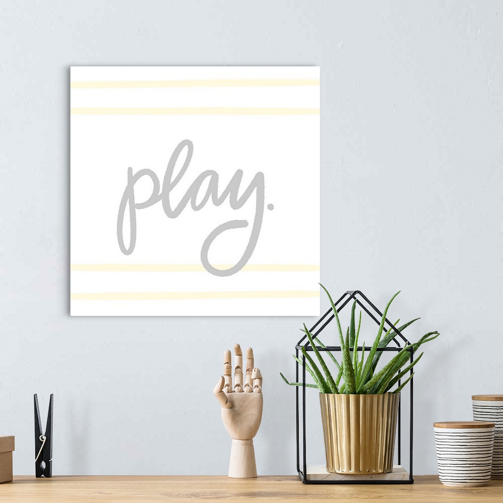 A bohemian room featuring "Play" in gray with light yellow horizontal lines on a white background.