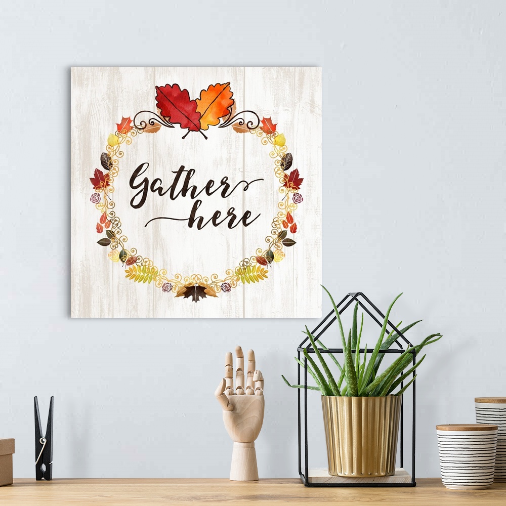 A bohemian room featuring "Gather Here" with a seasonal wreath and autumn leaves on a white wood backdrop.