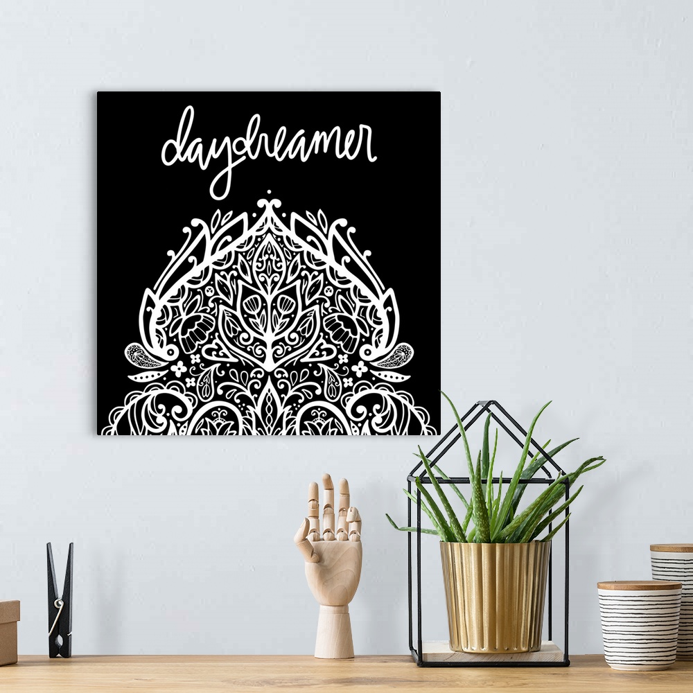 A bohemian room featuring "Daydreamer" with a elaborate mandala design in white on a black background.
