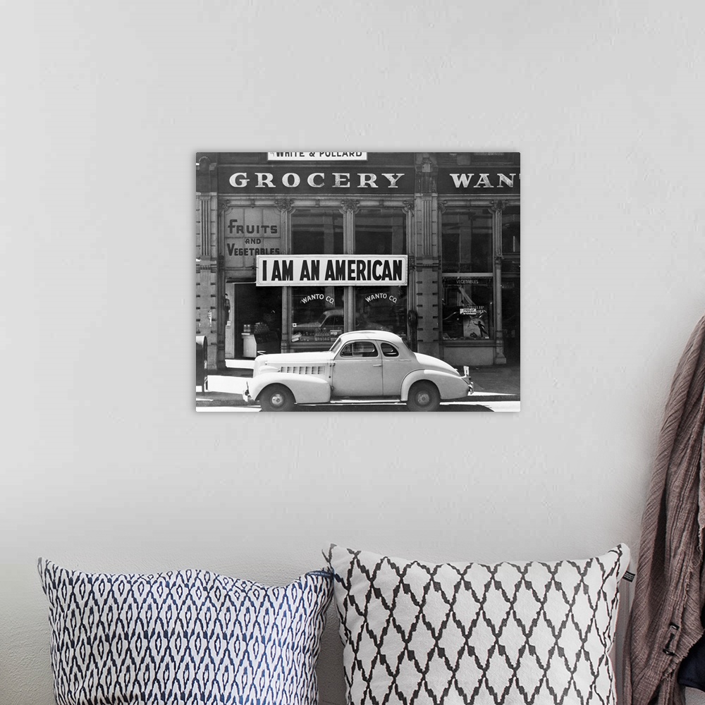 A bohemian room featuring A shop owned by Japanese Americans, bearing a sign reading, I am an American.