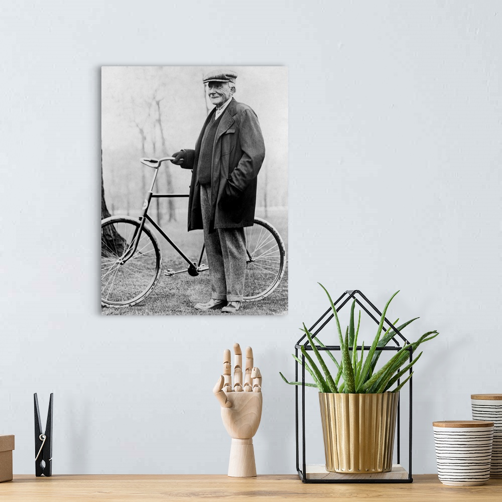A bohemian room featuring American business magnate John D. Rockefeller standing beside a bicycle in 1913.