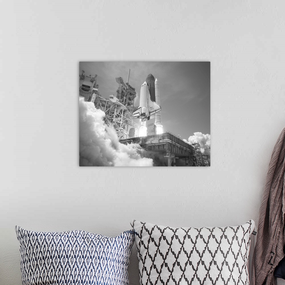 A bohemian room featuring American history photo of Space Shuttle Atlantis blasting off.