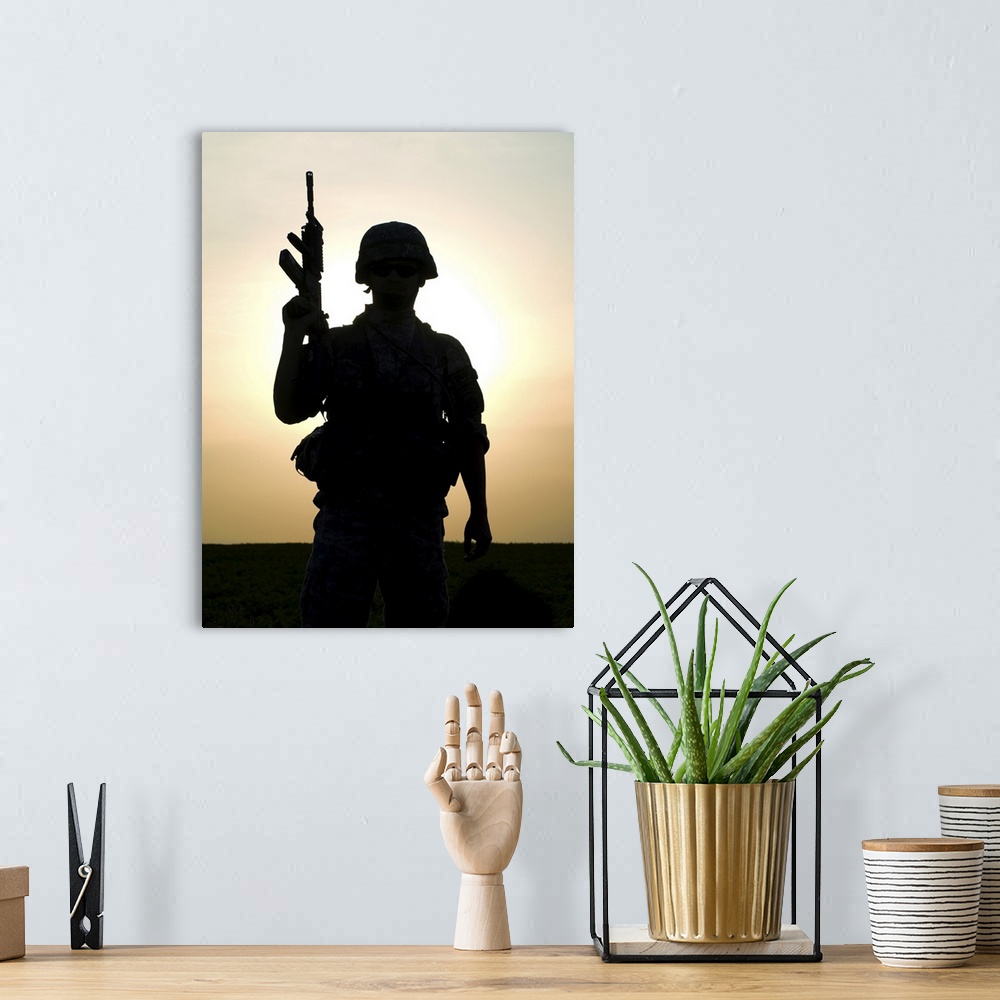 A bohemian room featuring Silhouette of U.S. soldier with rifle against a sunset.