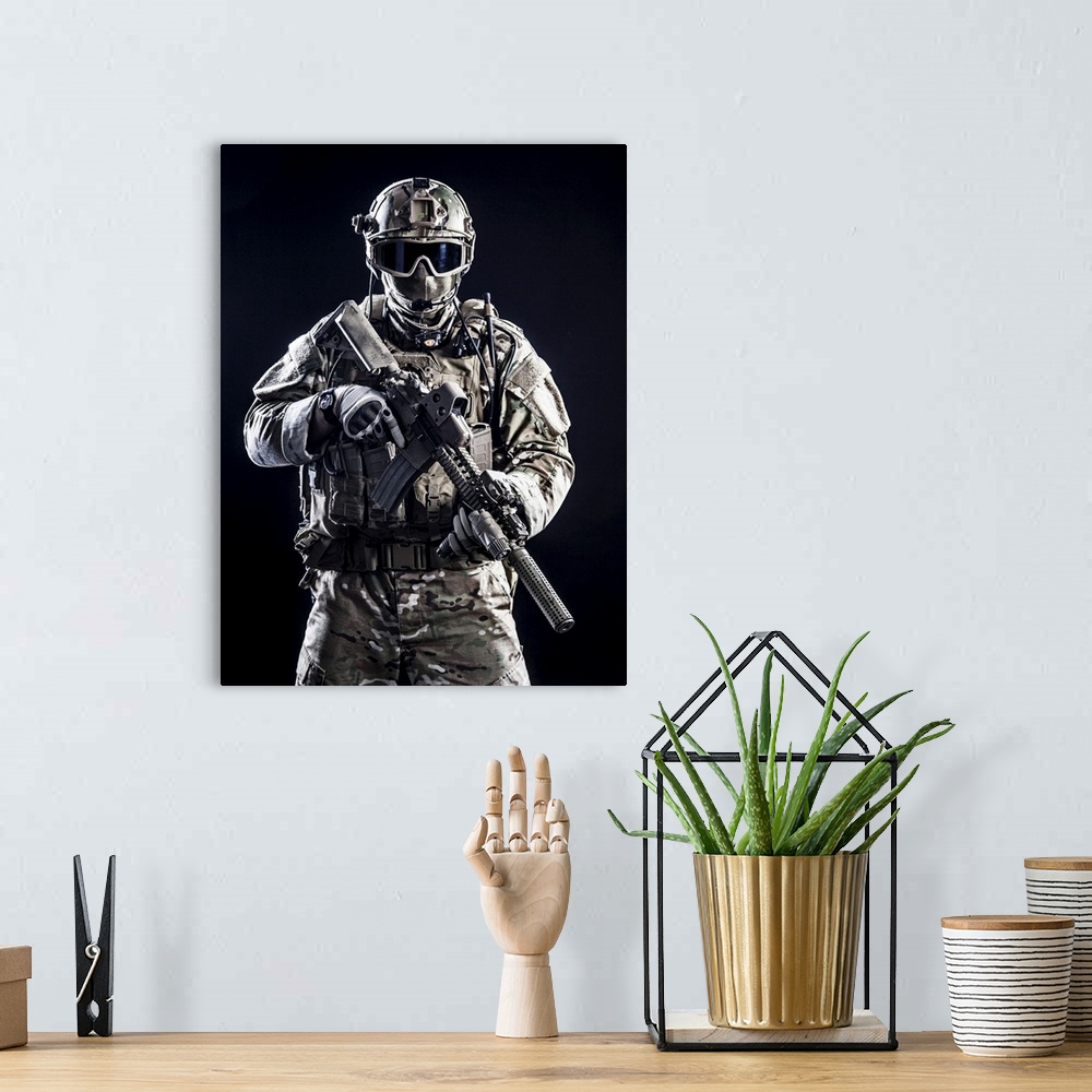 A bohemian room featuring Special forces soldier with rifle on dark background.