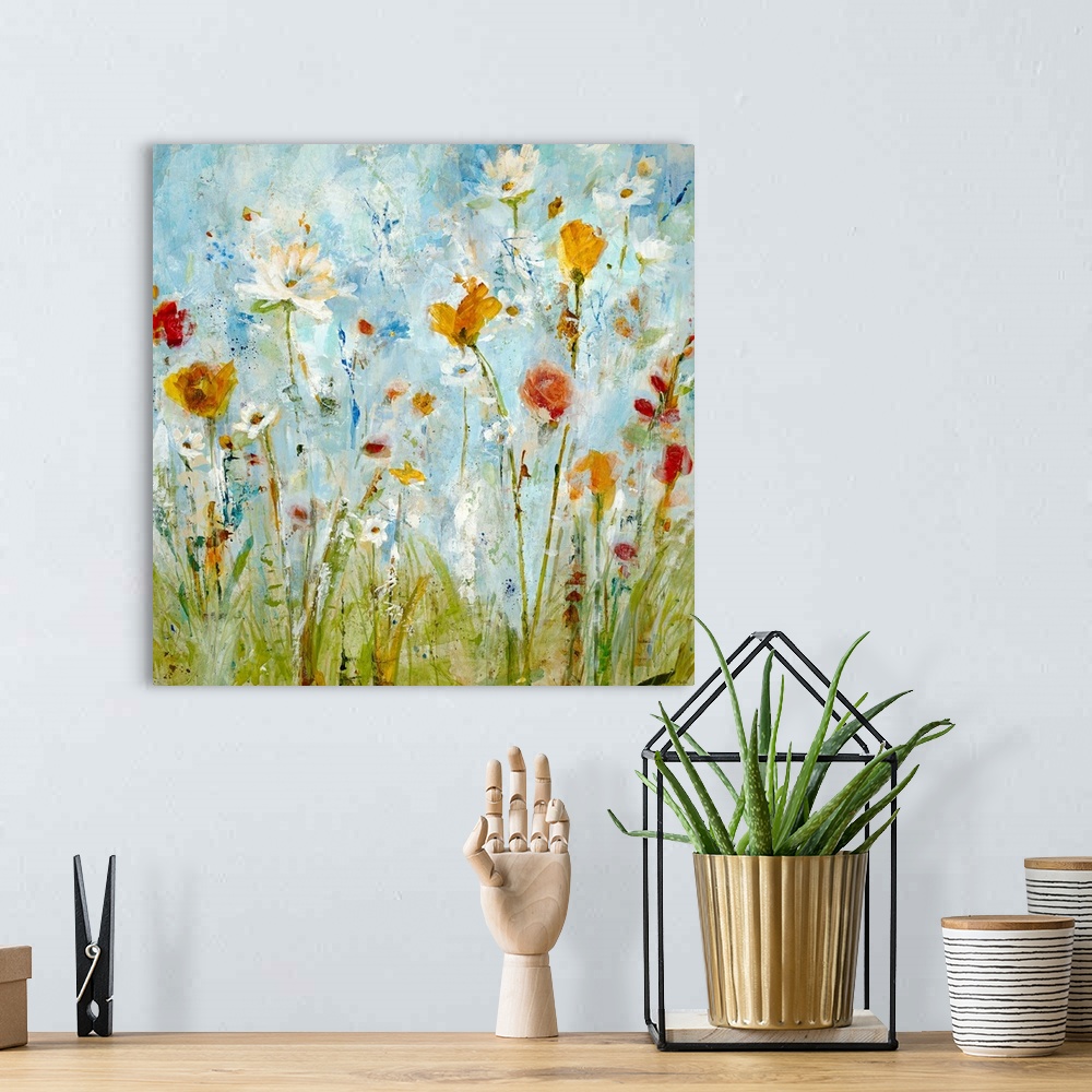 A bohemian room featuring A vertical abstract landscape painting of loosely painted flowers and grass that reminiscent of a...