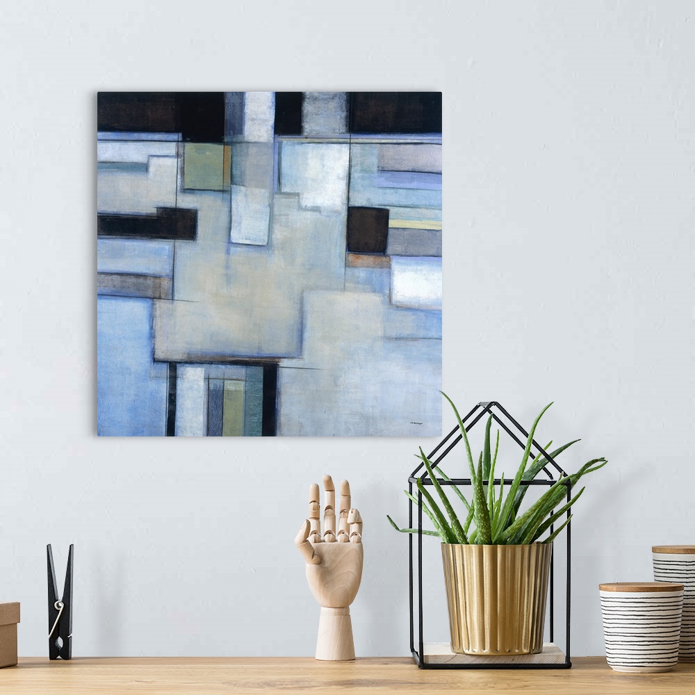 A bohemian room featuring A square abstract painting with square shapes in shades of blue.