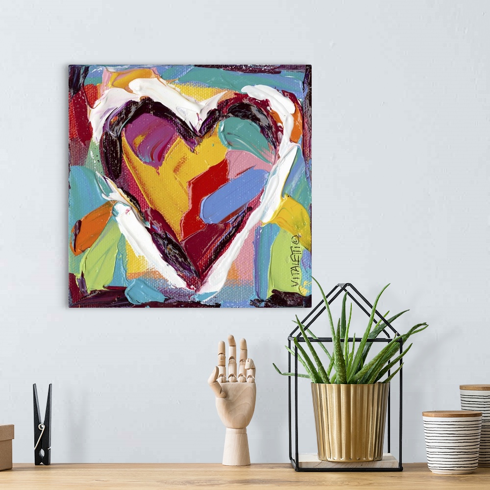 A bohemian room featuring Artwork of a technicolor heart with heavy dabs of paint and vivid colors.