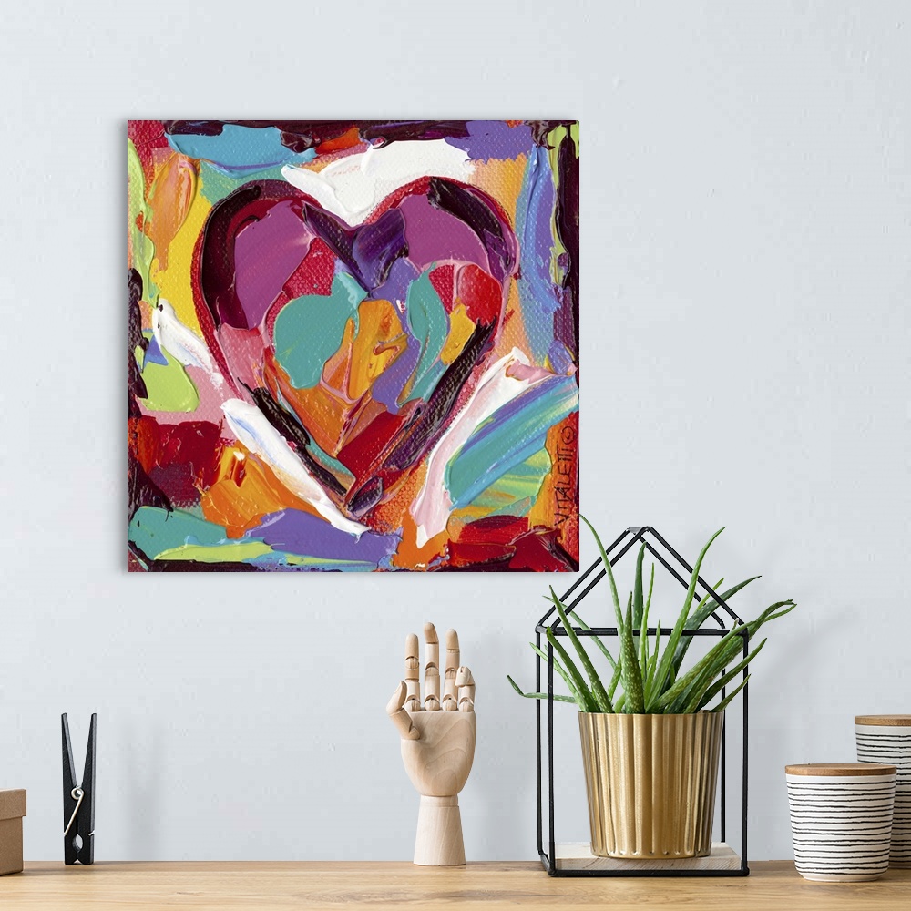 A bohemian room featuring Artwork of a technicolor heart with heavy dabs of paint and vivid colors.