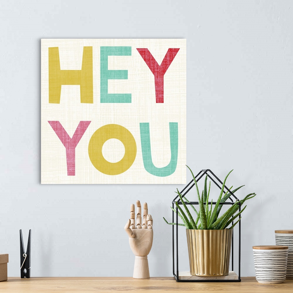 A bohemian room featuring Cute typography design with the words "Hey You" in large, pastel letters.