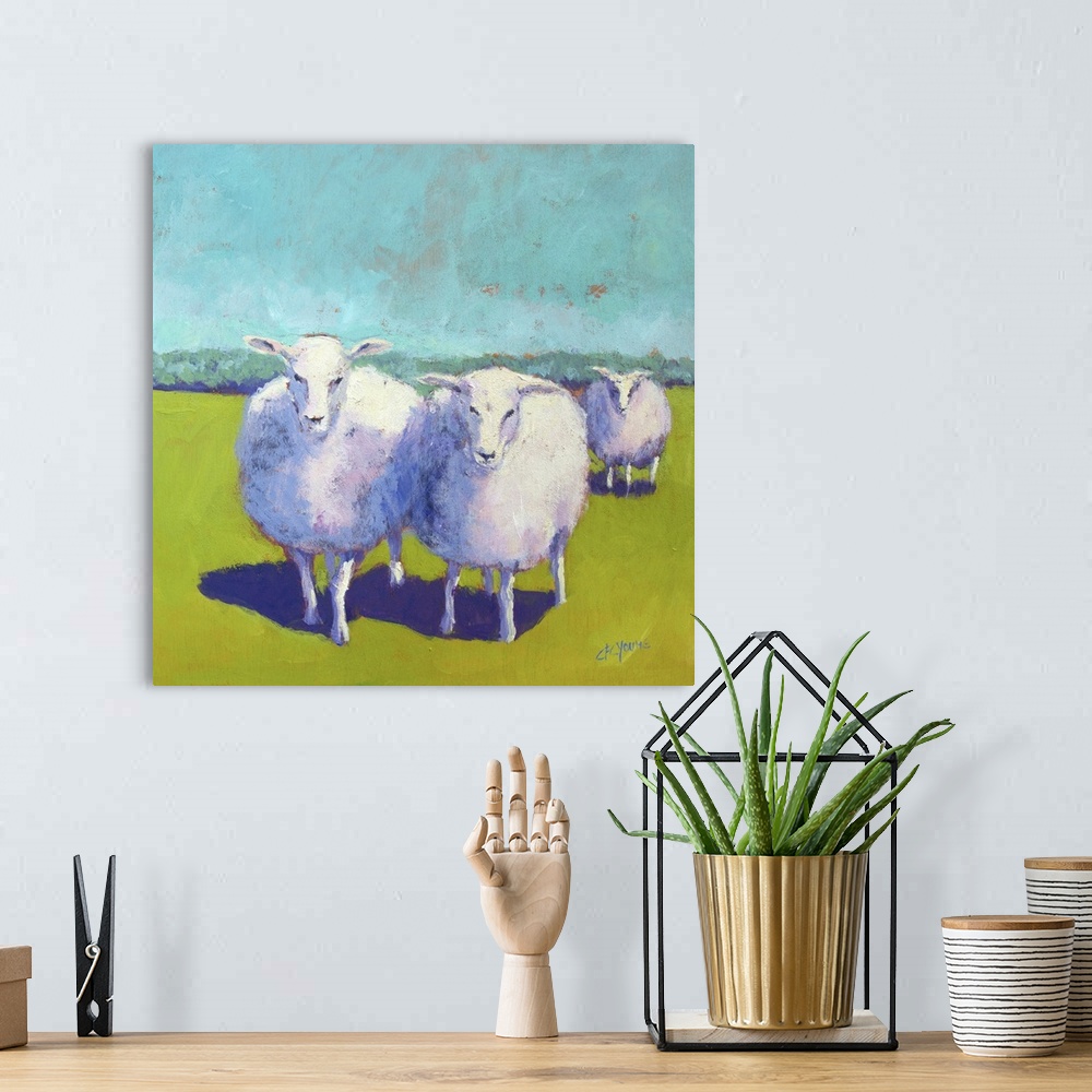 A bohemian room featuring Contemporary painting of three woolly sheep in a green field.