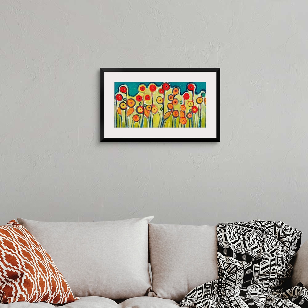 A bohemian room featuring Abstract painting of circular flowers growing out of the ground.
