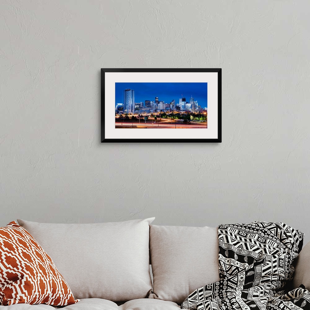 A bohemian room featuring Photo of Denver's skyline at night with light trails.