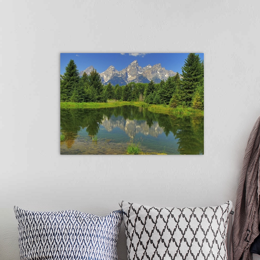 A bohemian room featuring Grand Teton mountains reflected on a still pond in Grand Teton National Park
