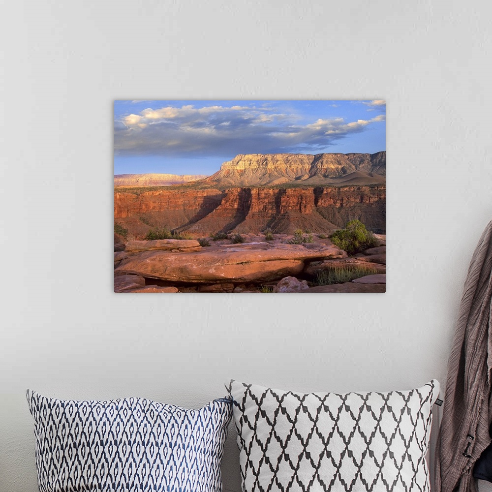 A bohemian room featuring Big landscape photograph of Aubrey Cliffs in the sunlight, beneath a cloudy blue sky, taken from ...