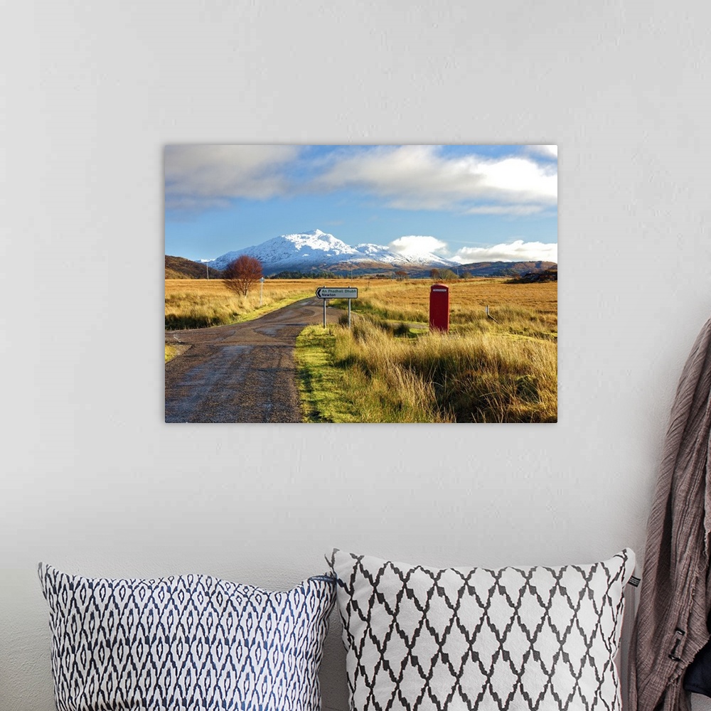 A bohemian room featuring Winter view of a red telephone box and road toward snow covered Beinn Resipol mountain in the moo...