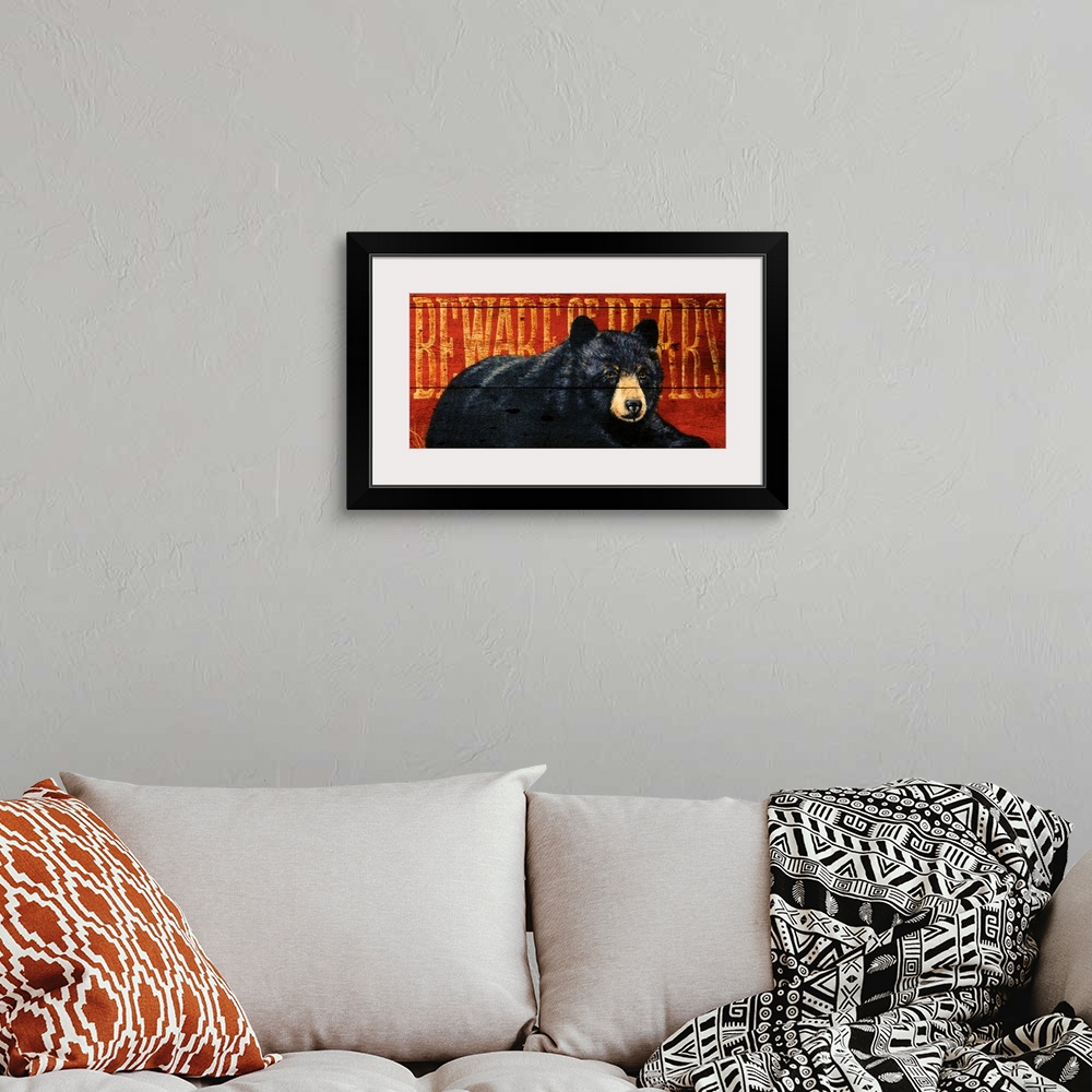 A bohemian room featuring Artwork of a black bear sitting on the ground with the warning ""Beware of Bears"" written behind...