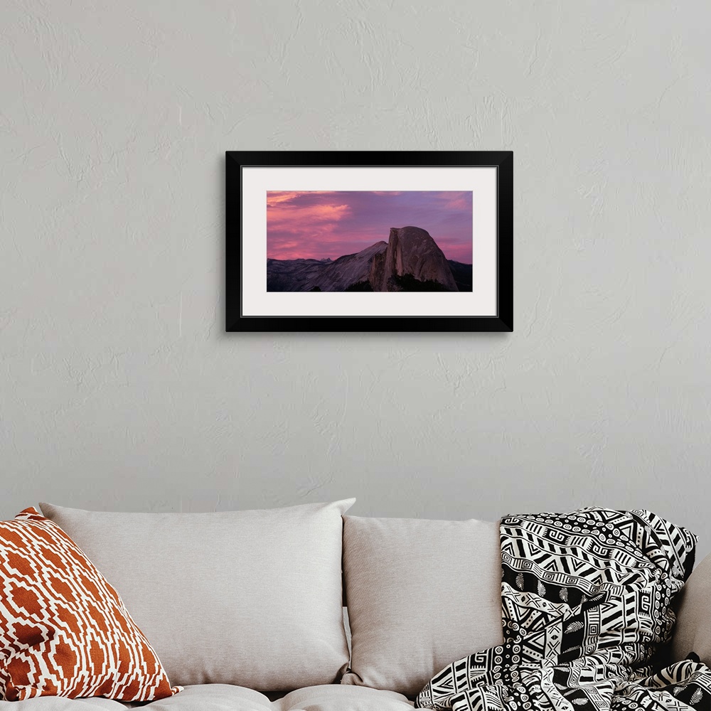 A bohemian room featuring Photograph of huge rock formation under a dark cloudy sky.