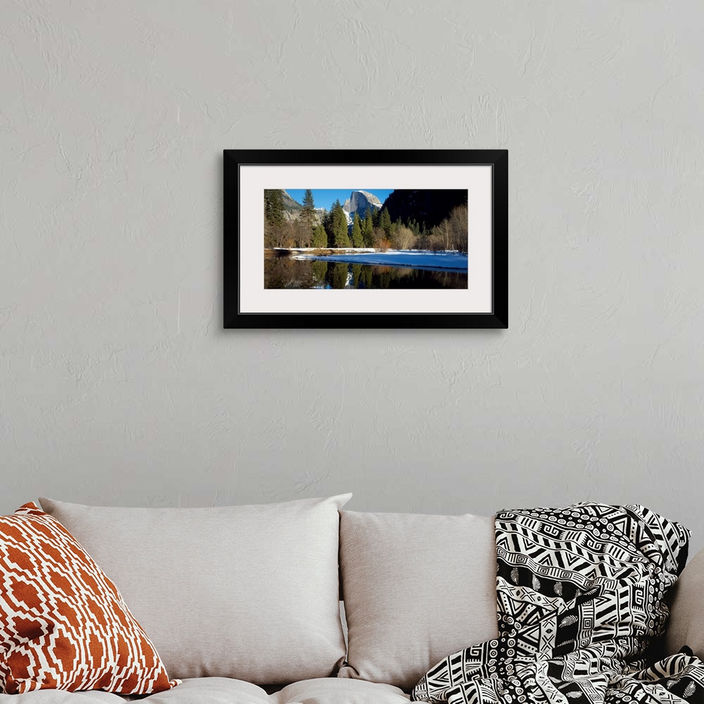 A bohemian room featuring This picture is taken of Yosemite during winter with trees lining the water and a view of a mount...