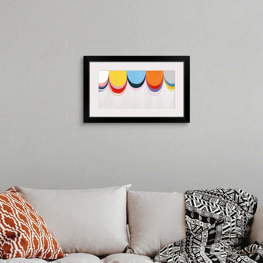 A bohemian room featuring Abstract painting with a cluster of brightly colored half circles that appear to have been pulled...