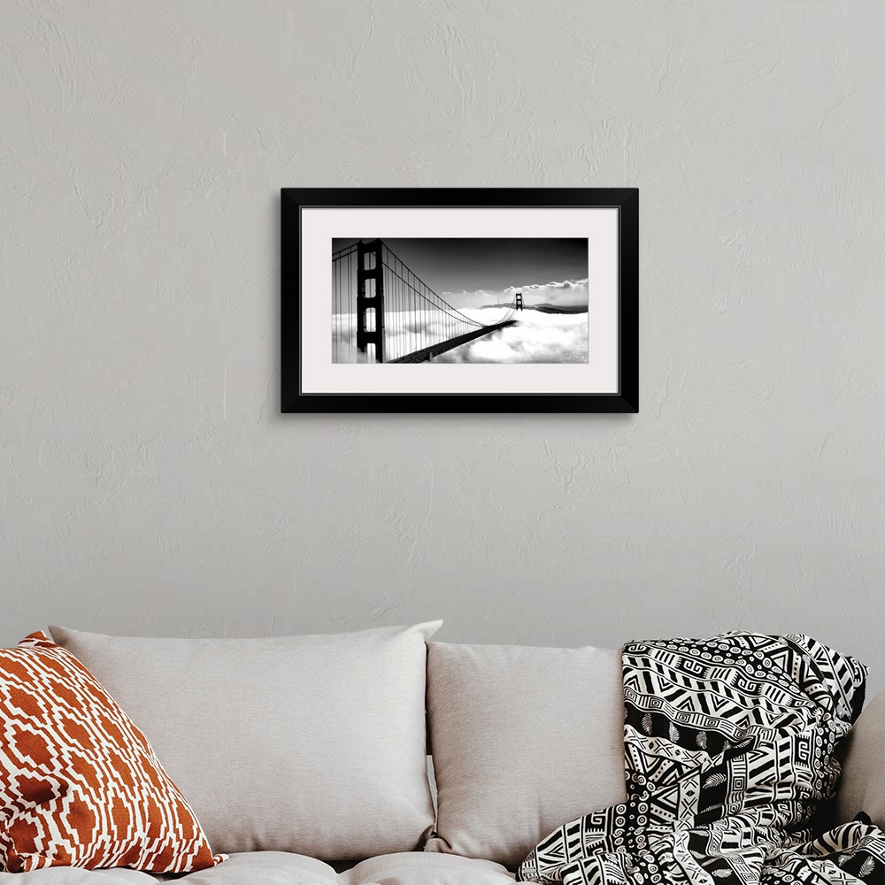 A bohemian room featuring Black and white image of the Golden Gate Bridge in San Francisco rising above the clouds.
