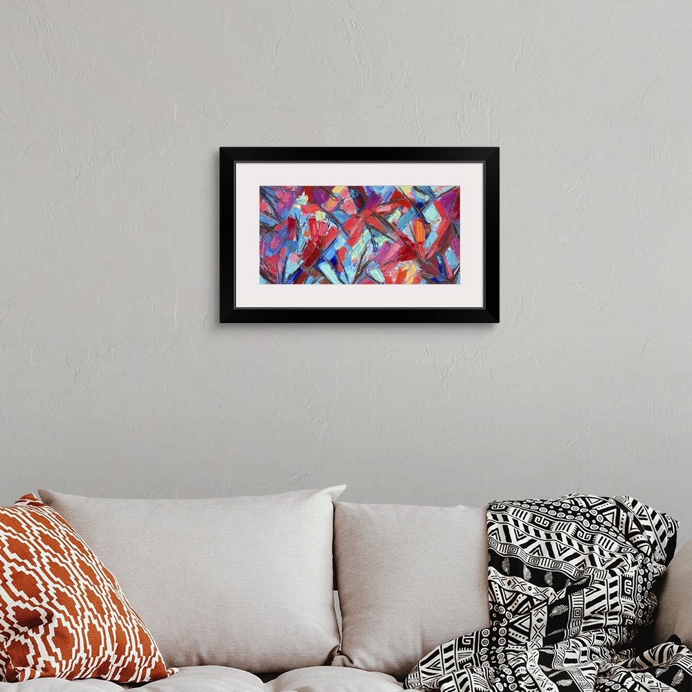A bohemian room featuring Vivid blue and red abstract artwork.