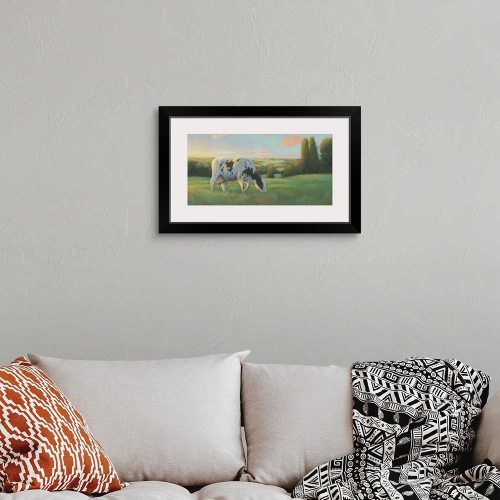 A bohemian room featuring Large contemporary painting of a cow grazing in a field at sunset.