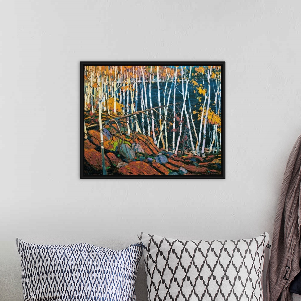 A bohemian room featuring A painting made on canvas of thin trees with rocks on the ground surrounding a lake.