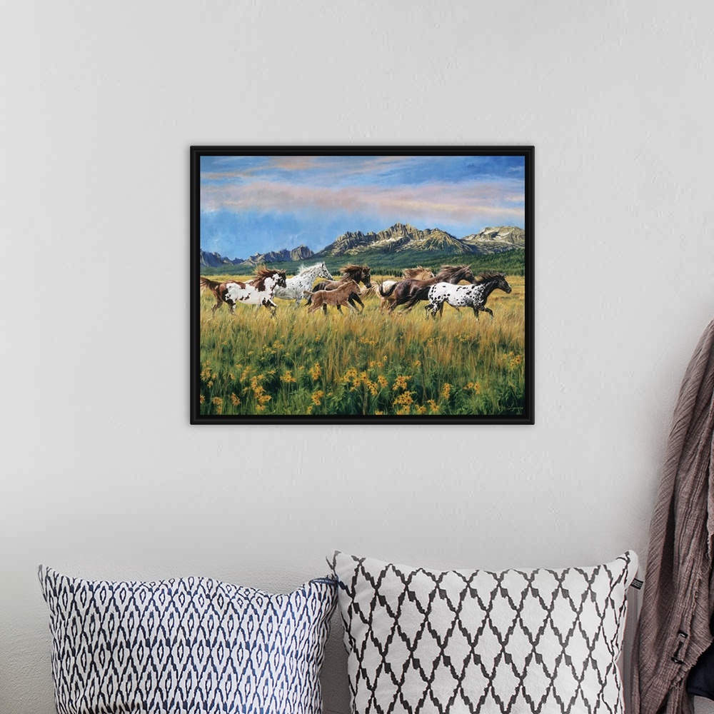 A bohemian room featuring Painting of wild horses running through a meadow of flowers and tall grass with mountains in the ...