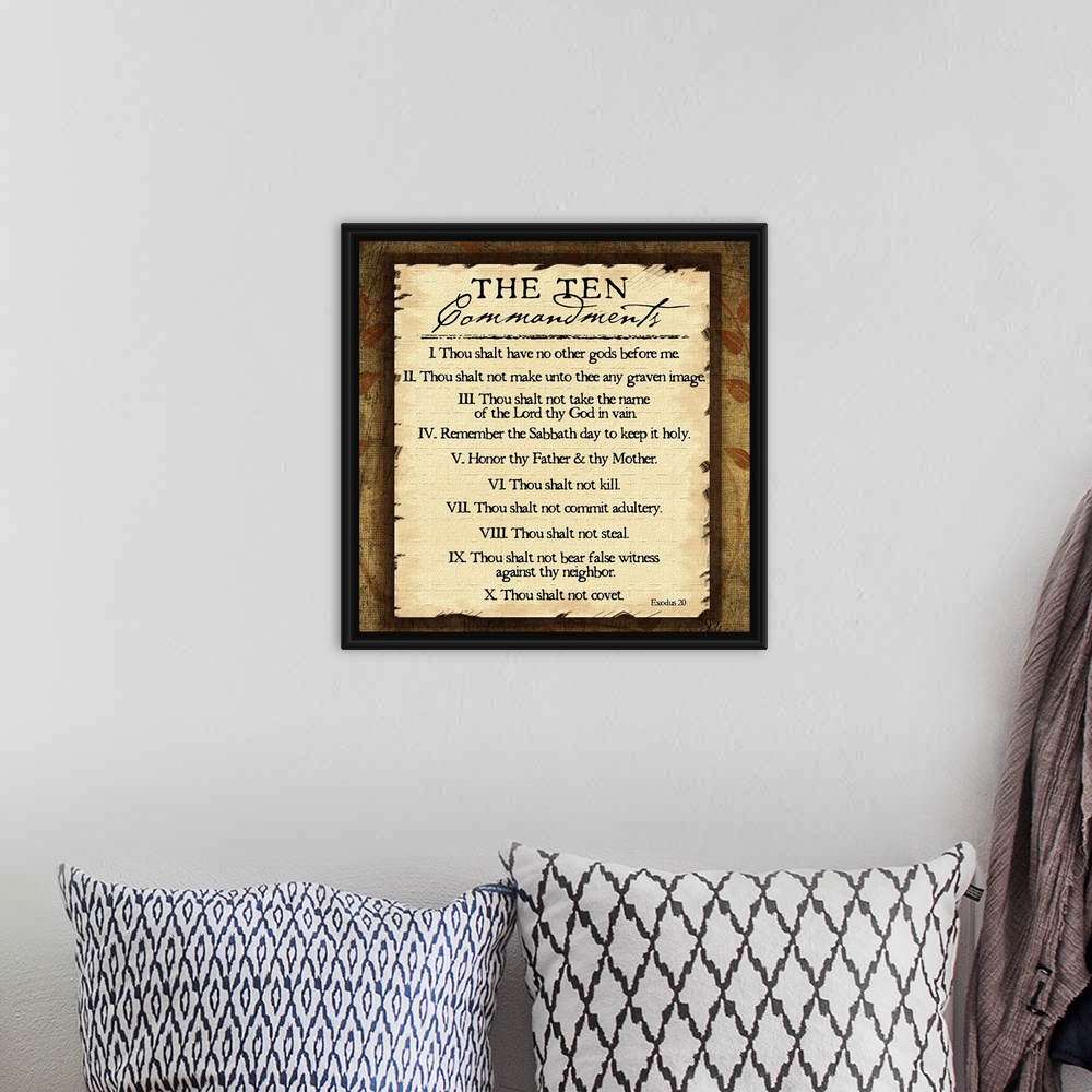 A bohemian room featuring This large square piece lists the ten commandments with a decorative border around them.