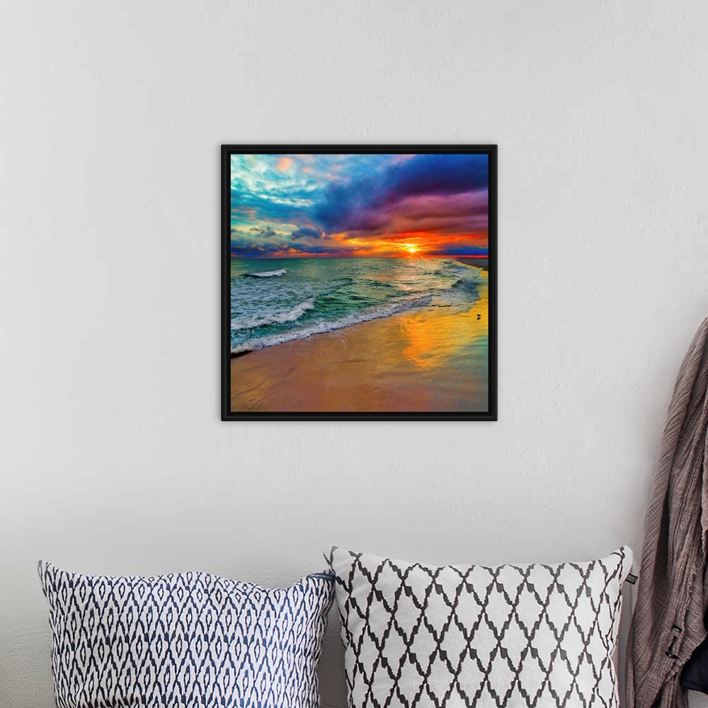 A bohemian room featuring A square image of the sun descending over the ocean amid bright, technicolor clouds.