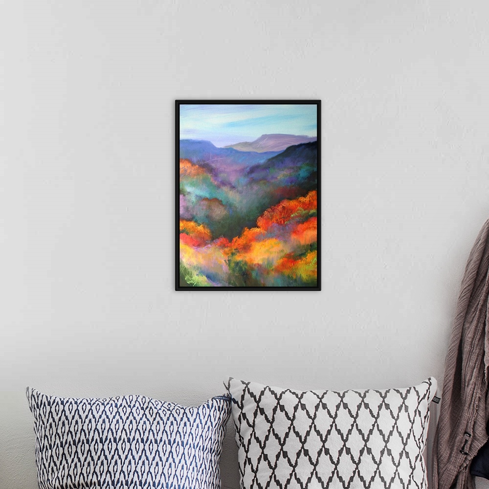 A bohemian room featuring Tall canvas painting of brightly colored trees with mountains in the distance.
