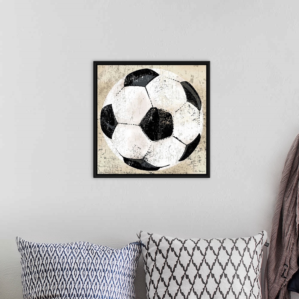 A bohemian room featuring Vintage style wall art of an old distressed soccer ball on tan and sepia background.