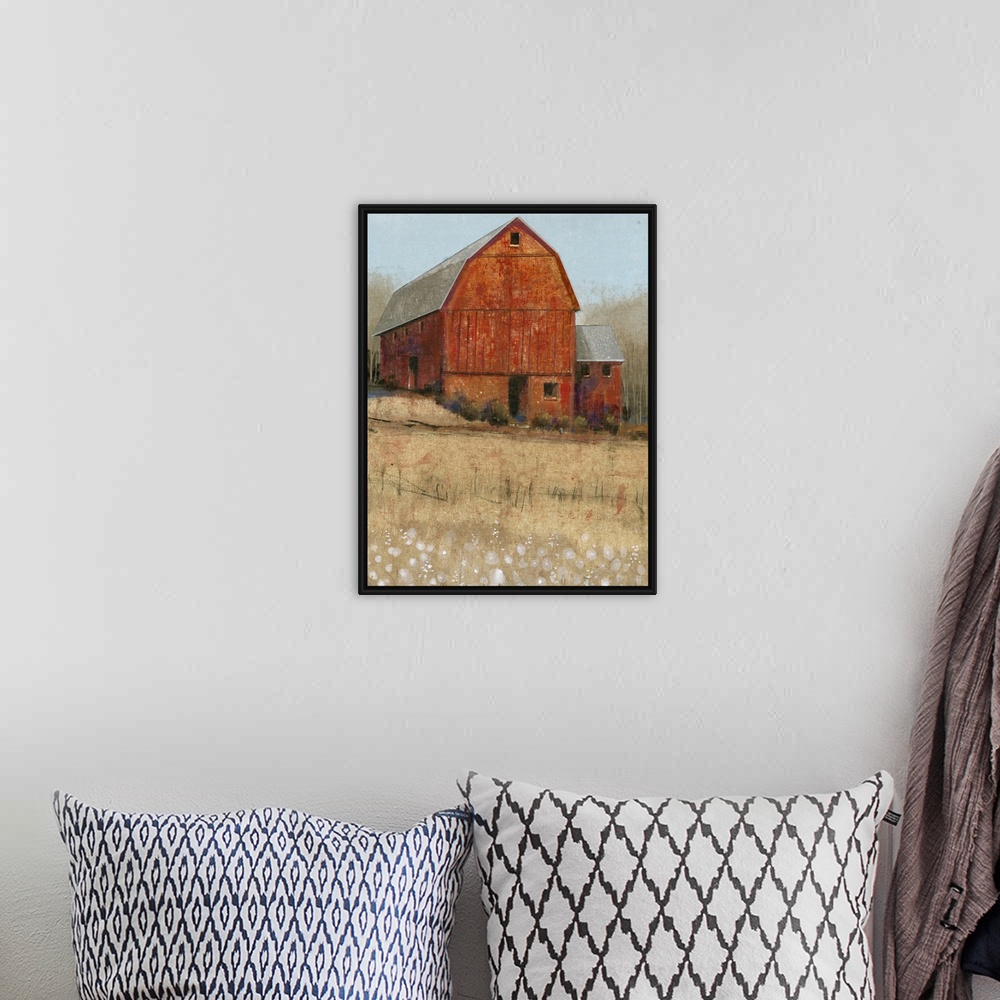 A bohemian room featuring Countryside artwork of rustic red barn on a straw colored field.