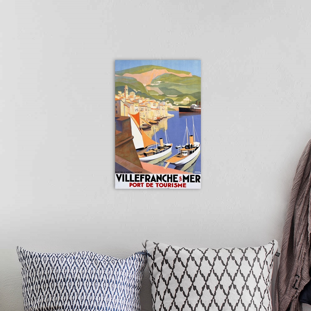 A bohemian room featuring Large vertical vintage poster showing ships in the water at a port city and large green hills in ...