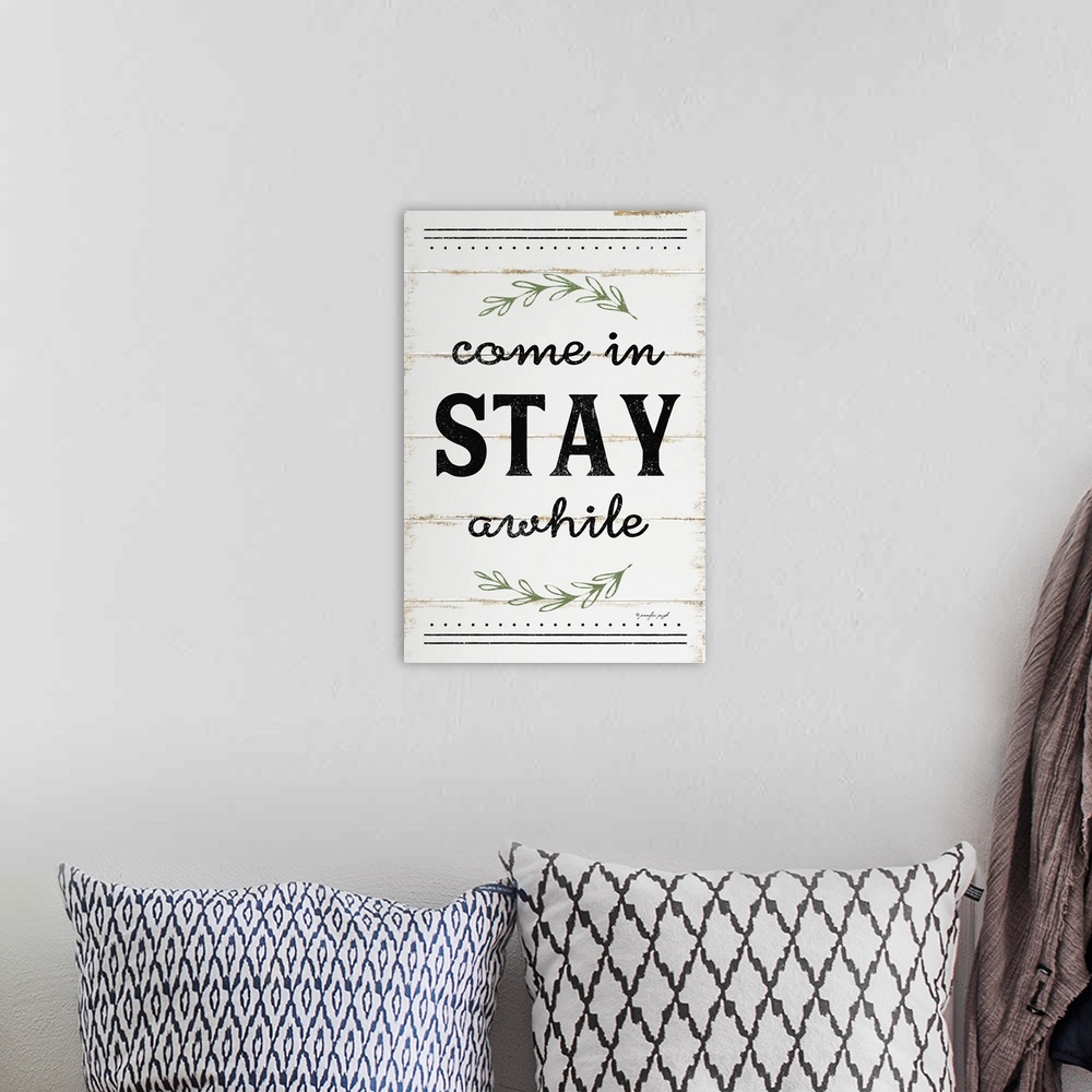 A bohemian room featuring A digital illustration of "Come in STAY awhile" on a white shiplap background.