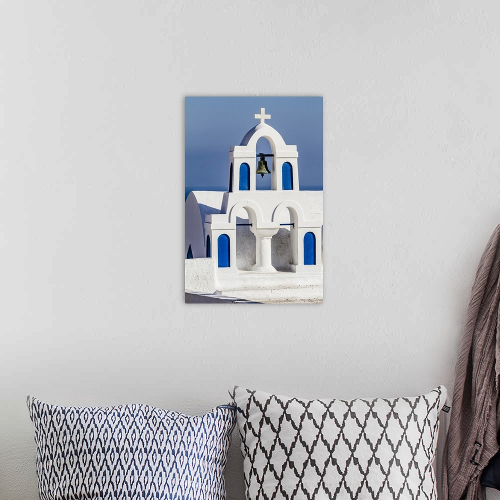 A bohemian room featuring Oia, Greece. Greek Orthdox Church steeple, cross, bell, and blue arches against Aegean Sea.