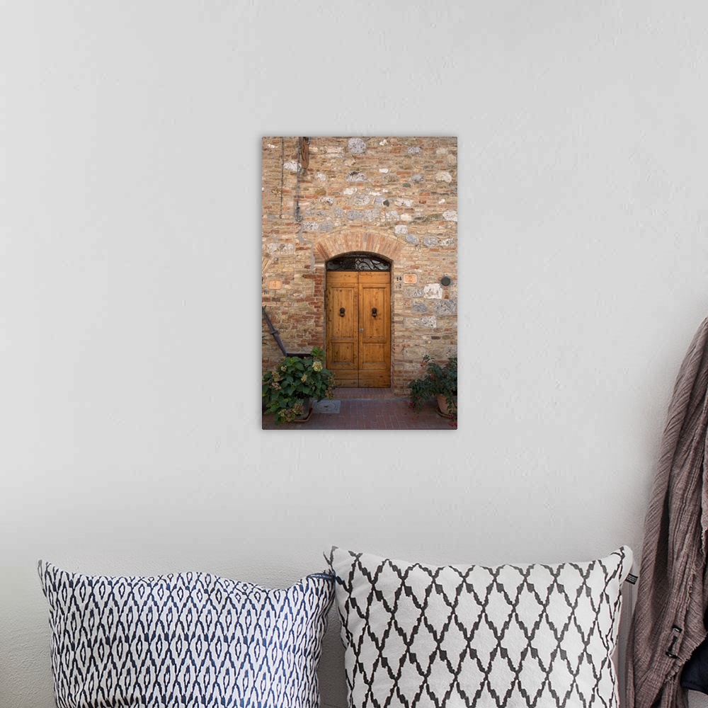 A bohemian room featuring Sienna, Tuscany, Italy - Wooden doors in a brick and stone building. Vertical shot.