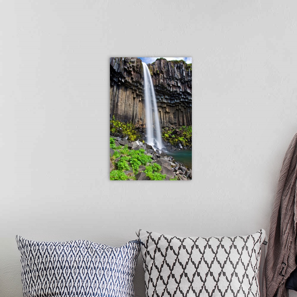 A bohemian room featuring Svartifoss, a waterfall in southern Iceland, cascades over ancient basaltic columns.