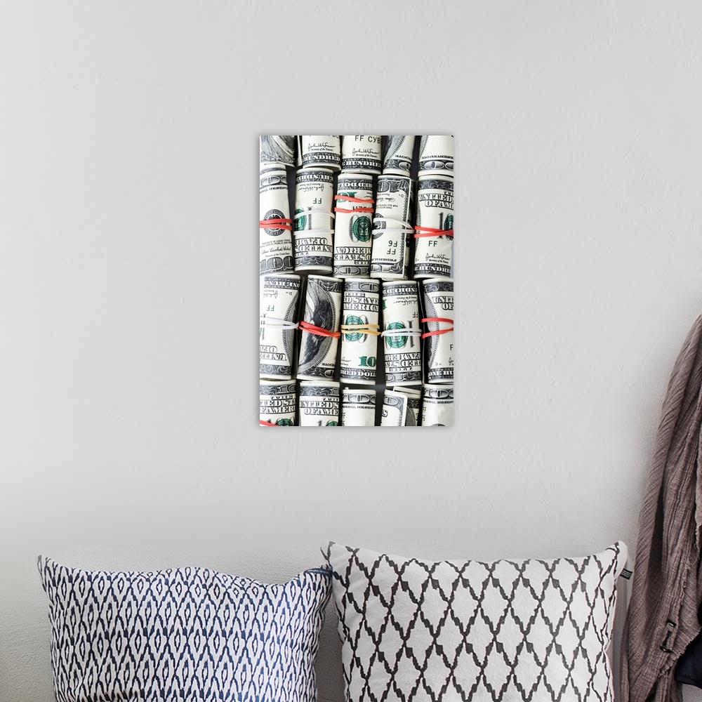 A bohemian room featuring Top view of cash rolls with colorful rubber bands.