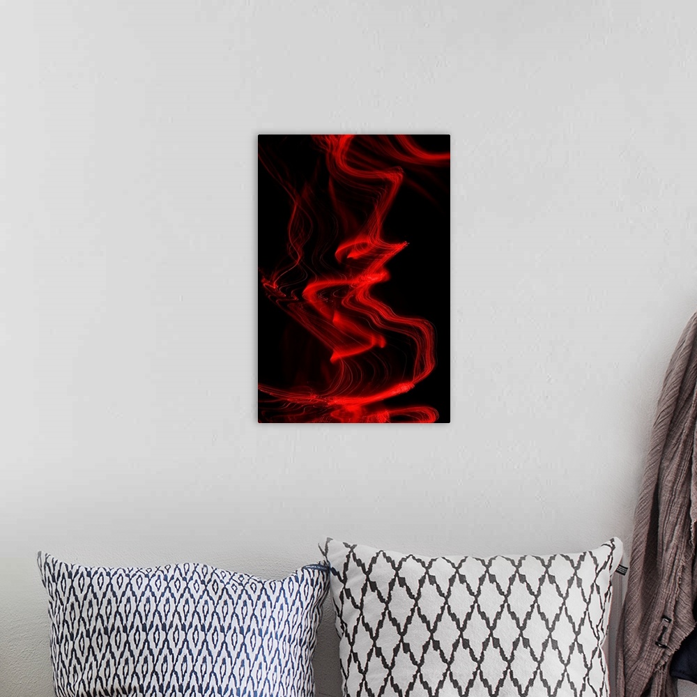 A bohemian room featuring Long exposure abstract photograph of red light trails resembling smoke with a black background.