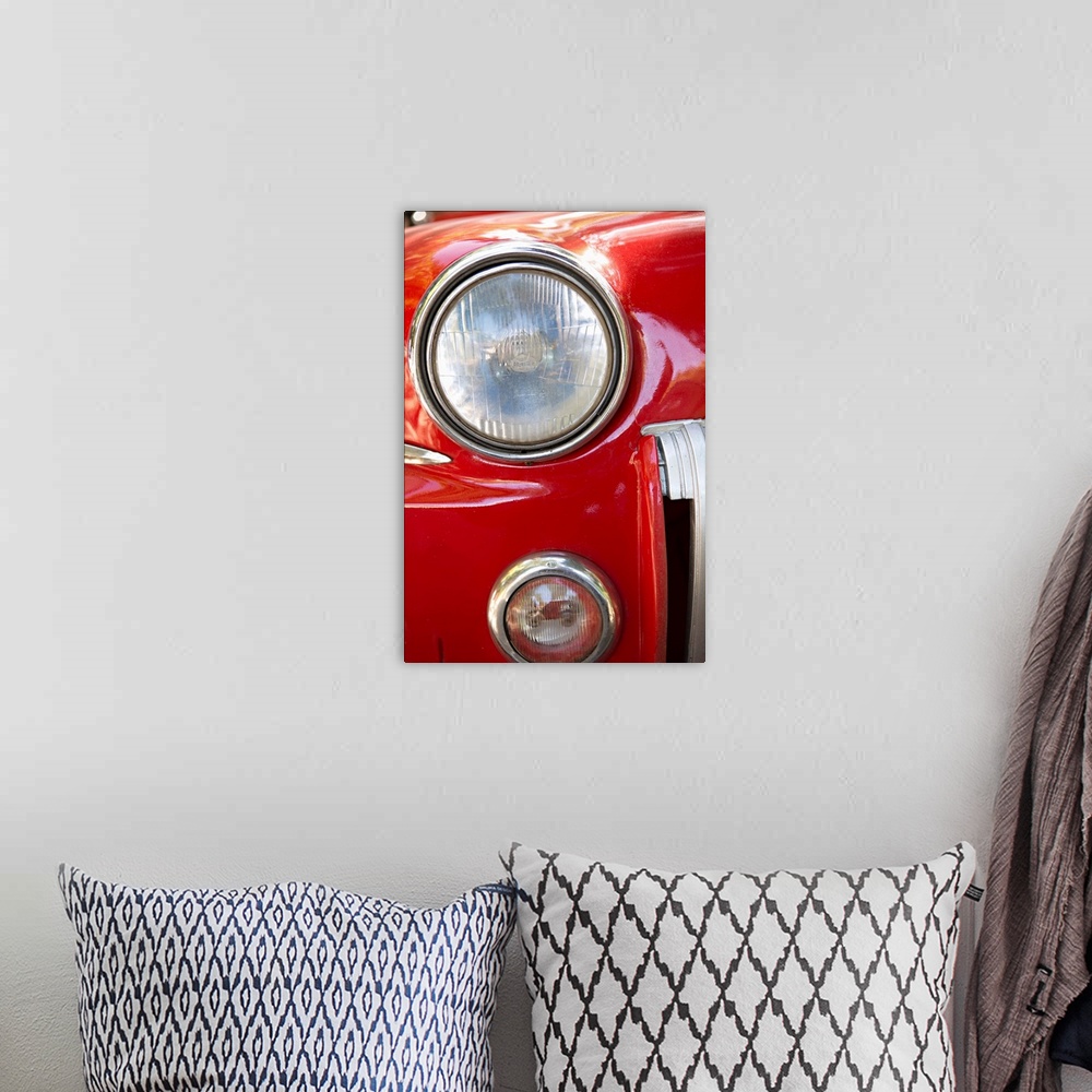 A bohemian room featuring Close-up photograph of the headlight of a red vintage car in Cuba.