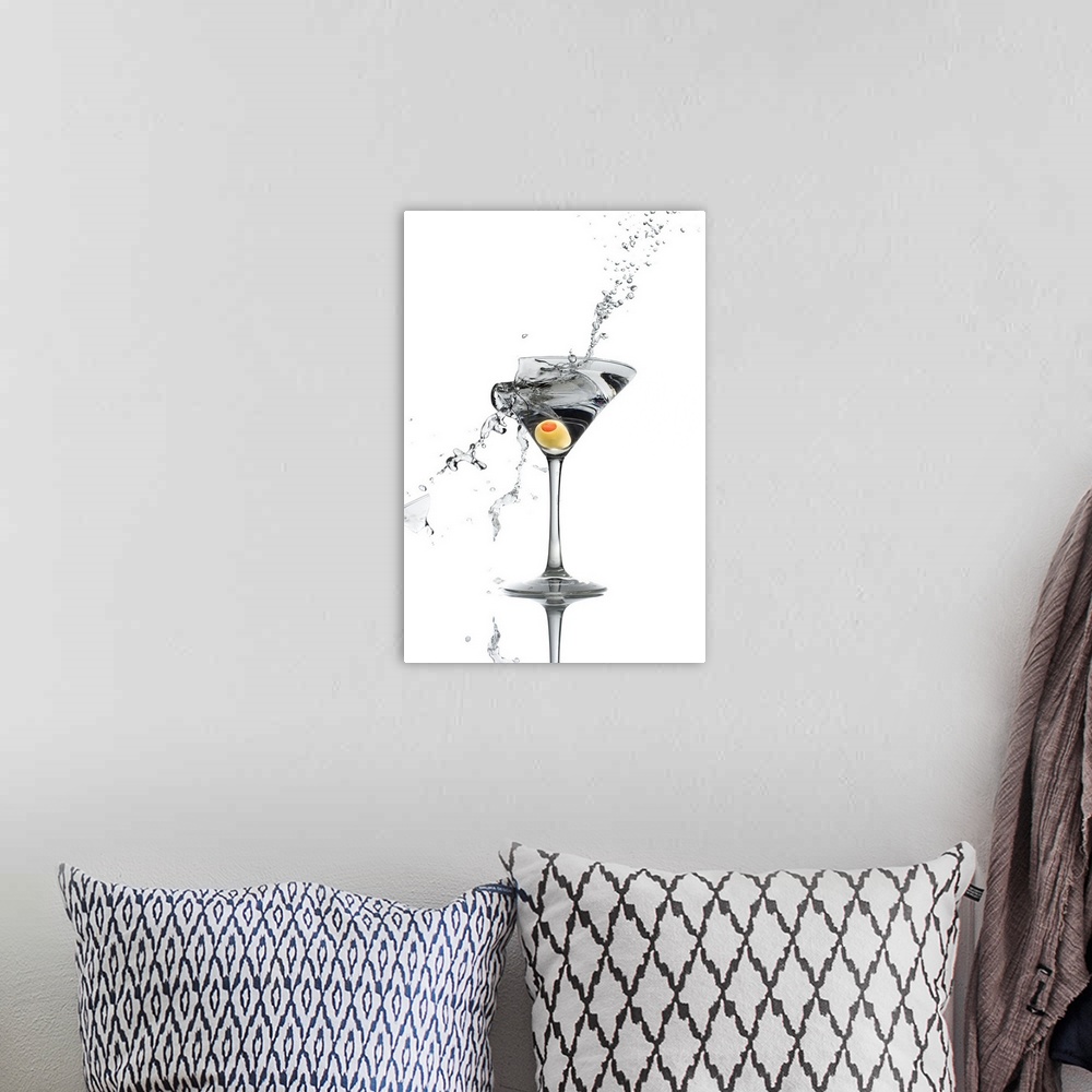 A bohemian room featuring A shattering martini glass on a white background spraying liquid outward.
