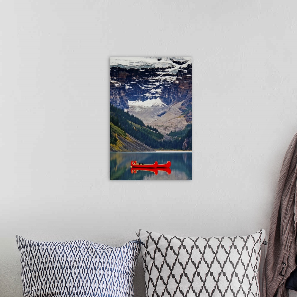 A bohemian room featuring Lake Louise, British Columbia Canada. Red canoe on the lake in front of glacier & snowy mountains.